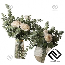 Два букета из роз и веток эвкалипта в стеклянных пупырчатых вазах